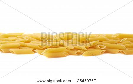 Pile of dried yellow penne pasta lined up in a row, composition isolated over the white background