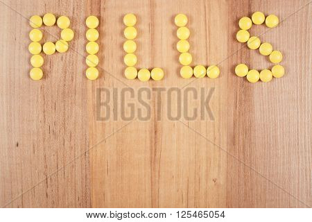 Inscription pills made of yellow medical tablets or supplements for therapy concept of treatment and health care copy space for text