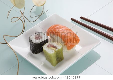 Sushi in eine kleine Schüssel mit hölzernen Stäbchen