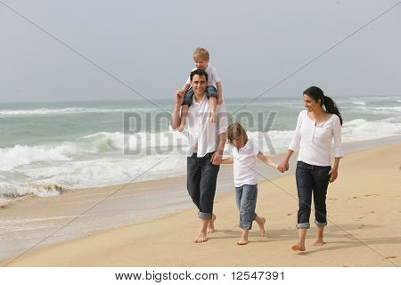 Retrato de uma família ter uma caminhada pela beira do mar