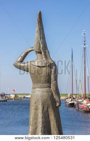 STAVOREN, NETHERLANDS - APRIL 11, 2016: Statue of a lady looking out over sea in Stavoren Netherlands