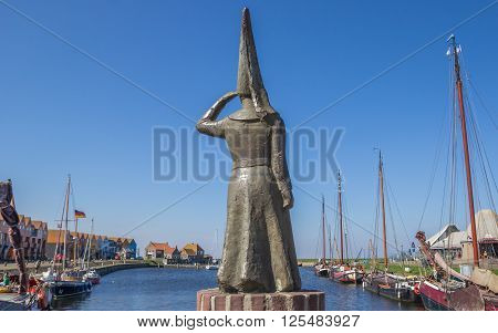 STAVOREN, NETHERLANDS - APRIL 11, 2016: Statue of a lady looking out over sea in Stavoren, Netherlands