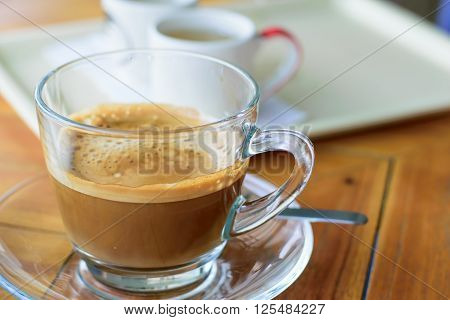 Morning cup of hot coffee with cream on table