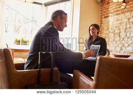 Guest checking in at hotel reception using tablet computer