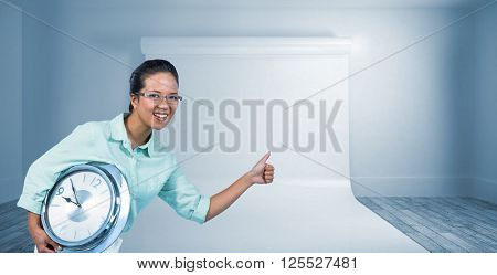 Delighted businesswoman holding a clock against large white screen