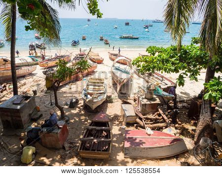 STONE TOWN ZANZIBAR - MARCH 28 2016: Local people with their boats on the seashore in Stone Town Zanzibar.