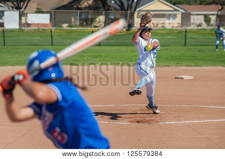 Close up of softball pitcher winding up to throw the curve ball to the batter.