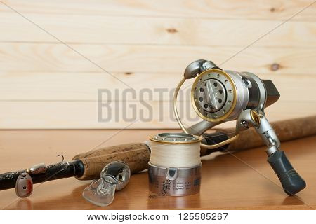 a fishing rod and reel on a wooden background