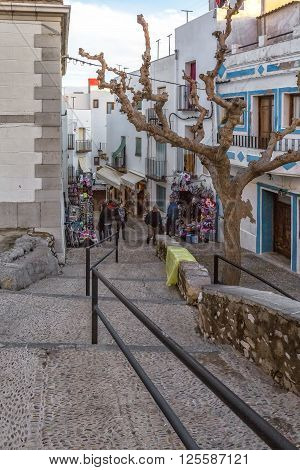 PENISCOLA SPAIN - MARCH 20 2016: Tourists in souvenir stores surrounding the Pope Luna's Castle in Peniscola Valencia Province Spain.