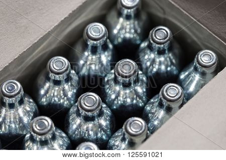 Soda chargers in carton box. Selective DOF, cole up shot.
