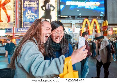 NEW-YORK - CIRCA MARCH 2016: women taking a selfie in New-York. A selfie is a self-portrait photograph, typically taken with a camera phone held in the hand or supported by a selfie stick.