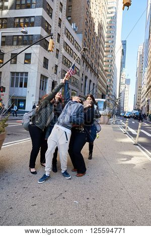 NEW-YORK - CIRCA MARCH 2016: people taking a selfie in New-York. A selfie is a self-portrait photograph, typically taken with a camera phone held in the hand or supported by a selfie stick.