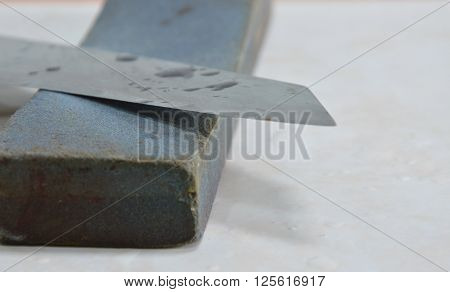 kitchen knife blade and grindstone on tile floor
** Note: Shallow depth of field