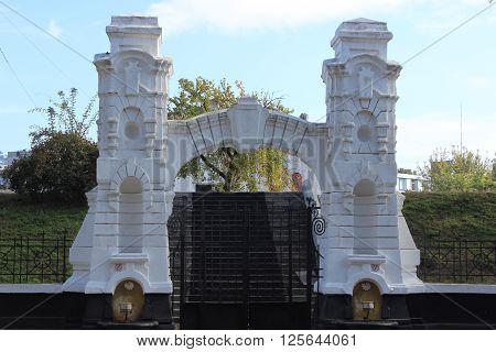Old stone arch entrance. Metal gates and stairs.