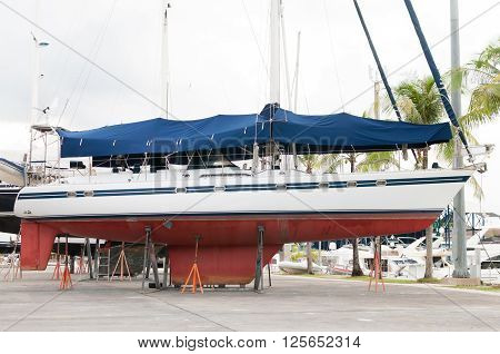 White sailboat at the shipyard for maintenance