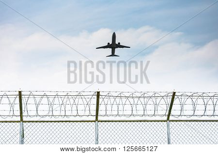 Airplane taking off from the airport over the fence of high security zone in Phuket Thailand