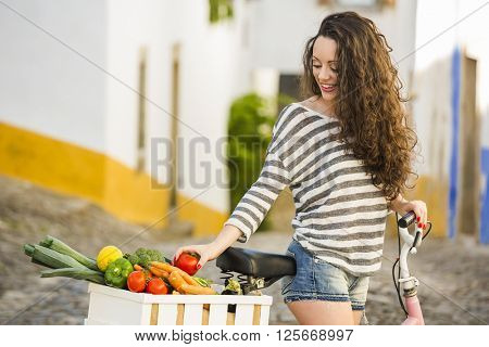 Beautiful female tourist living like a local, with her bicycle after buying some fresh vegetables