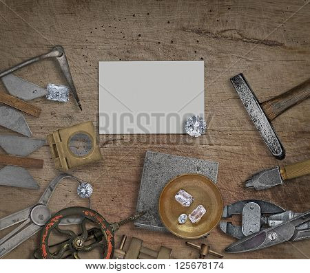 vintage jeweler tools and diamonds on a bench space for text on business card
