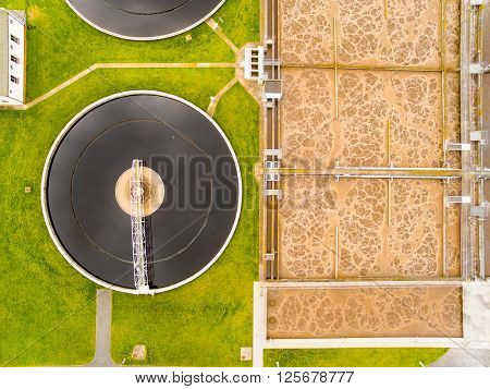 Aerial view to biogas plant from sewage treatment in green fields. Renewable energy from biomass. Waste management
