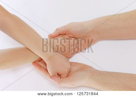 Child hands folded in a fist located in the mother's hands