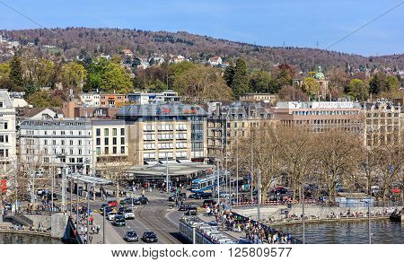 Zurich, Switzerland - 10 April, 2016: pedestrians and traffic on Quaibruecke bridge and Bellevue square, view from the Ferris wheel temporarily installed on Burkliplatz square. Zurich is the largest city in Switzerland.