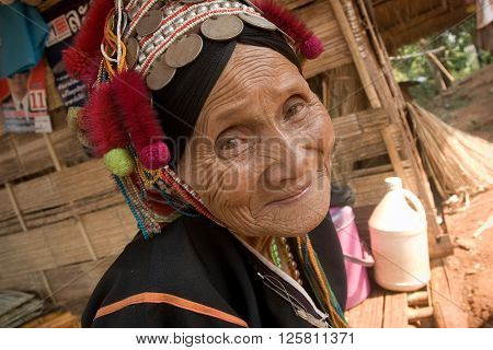 MAE SALONG,  CHIANG RAI province , THAILAND - JUN, 2004 : 
In the mountains of northern Thailand. An old woman from the Akha ethnic group. To save her money Akha women sew silver coins on headdress.