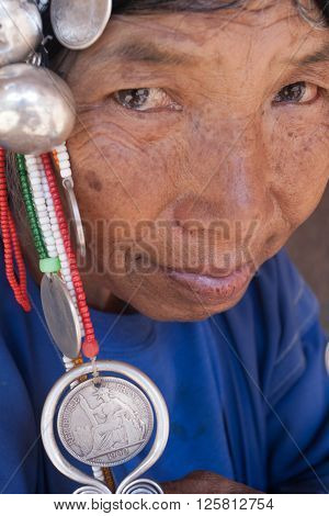 MAE SALONG,  CHIANG RAI province , THAILAND - JUN, 2004 : 
In the mountains of northern Thailand. An old woman from the Akha ethnic group. To save her money Akha women sew silver coins on headdress.