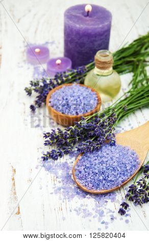 Lavender with essencial oil and candle on a wooden background
