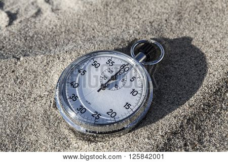 analog Stopwatch on wet sea sand closeup