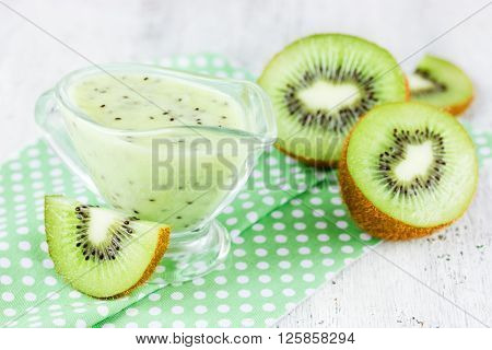 Fresh kiwi fruit and green kiwi sauce on a white background tasty and healthy dressing selective focus