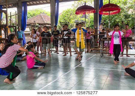 UBUD, INDONESIA - MAR 1, 2016: Unidentified teenagers at the time of preparations for Ngrupuk parade, which takes place on the eve of Nyepi day in Bali. Nyepi is a public holiday in Indonesia.