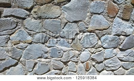 The laying of natural stones; a wall of colored stones