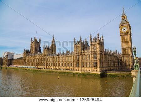 A side view of the Palace of Westminster in London during the day. There is space for text