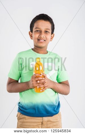 indian boy with cold drink bottle, asian boy holding cold drink bottle, small boy and cold drink, indian cute boy drinking mango juice or orange juice in plastic bottle