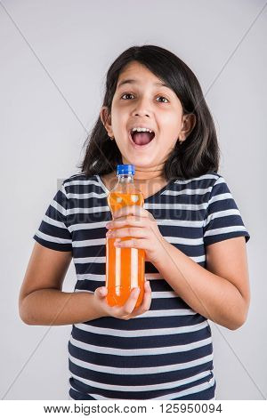 indian girl with cold drink bottle, asian girl drinking cold drink in pet bottle, girl kid and cold drink, indian cute girl drinking mango juice or orange juice in plastic bottle
