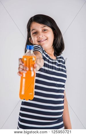 indian girl with cold drink bottle, asian girl drinking cold drink in pet bottle, girl kid and cold drink, indian cute girl drinking mango juice or orange juice in plastic bottle