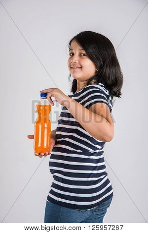indian girl with cold drink bottle, asian girl drinking cold drink in pet bottle, girl kid and cold drink, indian cute girl drinking mango juice or orange juice in plastic bottle