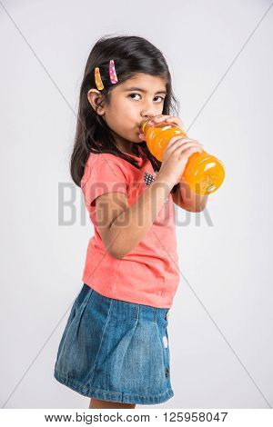 indian girl with cold drink bottle, asian girl drinking cold drink in pet bottle, girl kid and cold drink, indian cute girl with mango or orange cold drink in plastic bottle, isolated