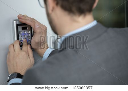 Close up of businessman hand pressing button on security system