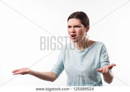 Completely dissatisfied.  Cheerless emotional irritated girl using gestures and expressing range while standing isolated on white background