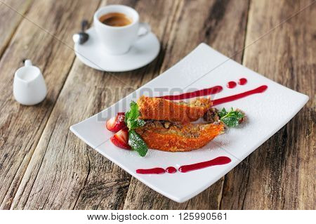 Vegetarian dessert. Carrot apple  sweet roll  with a strawberry sauce and a cup of espresso coffee served on wooden background. Lenten vegetarian desert from fruits.