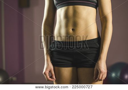 Flat tummy of young female training at fitness club, beautiful healthy fit body