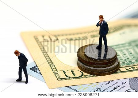 Winning and losing businessmen figurines. Miniature model. Cash banknotes and coins. Successful business strategy. Withdrawal competitor from market. Profit growth. Career achievement. Fired from work