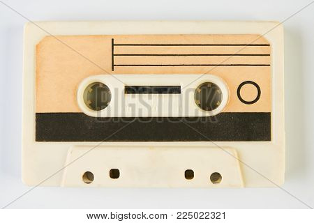 Old compact audio cassette. Vintage cassette tape isolated white background, close-up top view. Cassetes year 1980