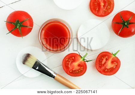 Tomato Pulp Mask Recipe for skin beauty treatment. Homemade vegan mask with fresh juicy red tomato, ingredients viewed above preparation white wooden table.