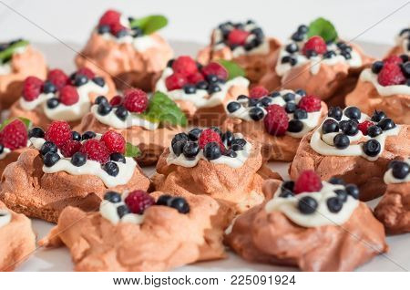 Mini Pavlova meringue nests with berries and mint on isolated on white
