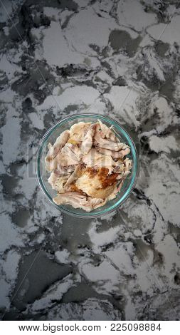 Shredded roast white chicken meat in a glass bowl on a marble counter top. most downloaded chicken meat image