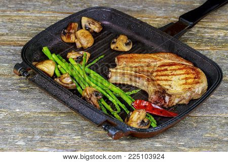 Grilled steak Grilled striploin sliced steak. Juicy thick grilled steak seasoned with rosemary fresh of plate with salt and pepper steak plate with asparagus mushrooms