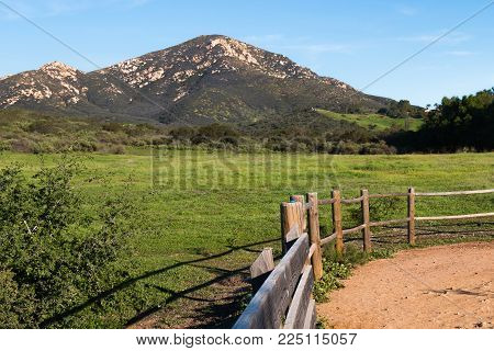 View of Iron Mountain in Poway, California with wooden fence on a hiking trail.