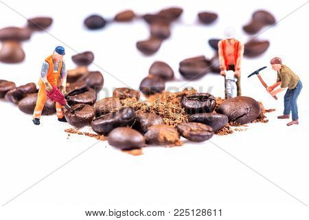 Miniature figures working on coffee macro photography on white background